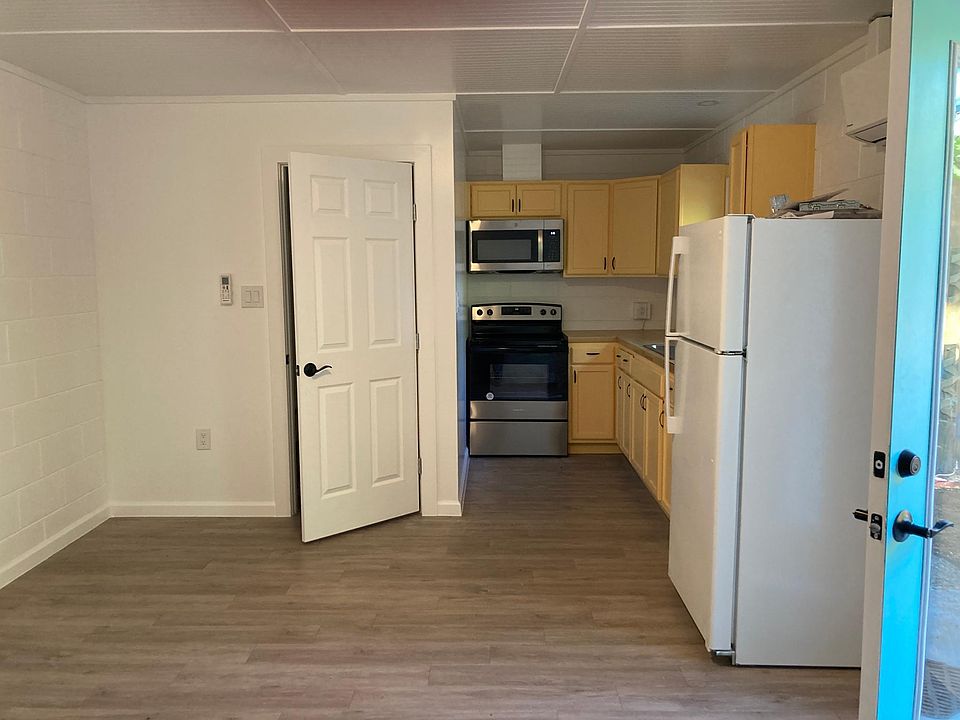 Door to bathroom and long view of kitchenette.