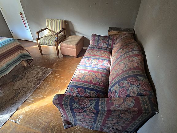 The room for rent features a couch, a bed, a chair, and a chest of drawers in the closet plus a sotorage loft.