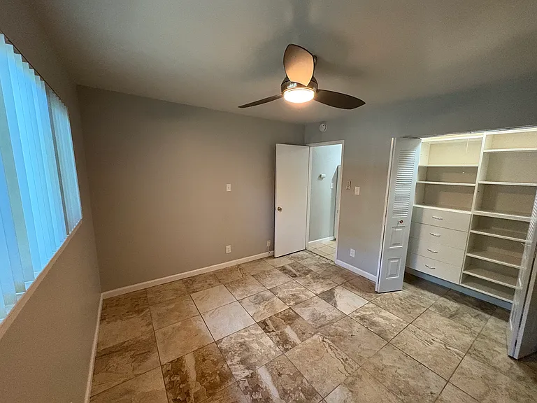 Master bedroom with beautifully organized closet and contemporary tile