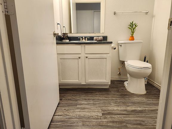 Explore this sleek, contemporary bathroom featuring stylish wood-style flooring and minimalist design.