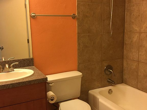 Efficient, pretty master bath has a tub and lots of storage.