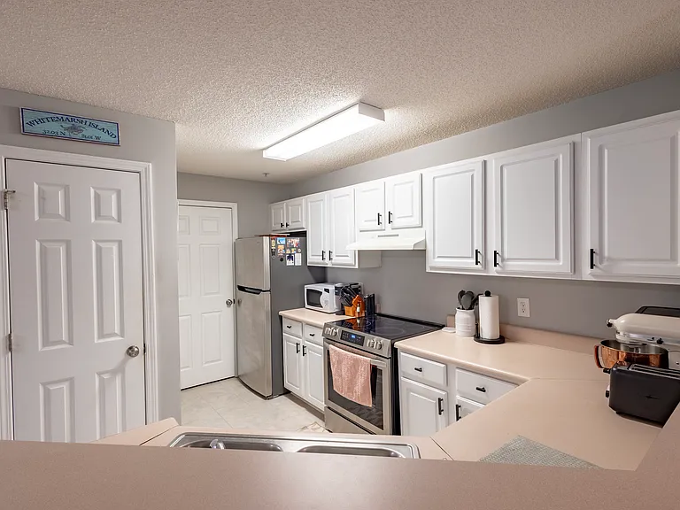 Kitchen with access to pantry(front left door) and Laundry Room (back door)