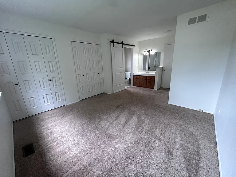 Primary Bedroom with barn door open into ensuite