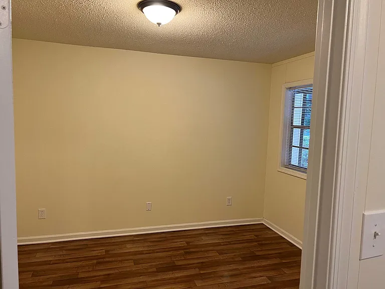 Bedroom with updated flooring and lighting