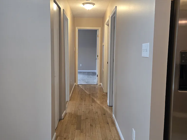 Hallway leading to a coat closet, laundry, bathrooms, and 2 large bedrooms