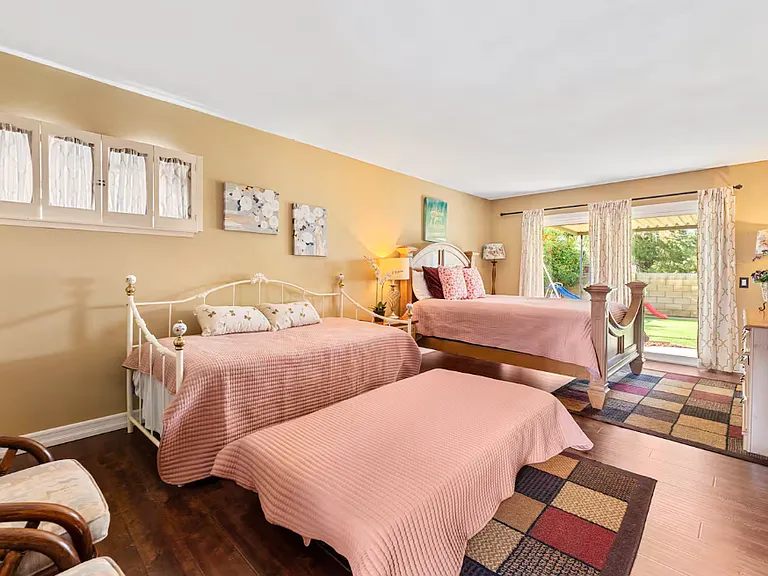 Picture of the owner suite shows how big this room is. The furnitures on the left side, the day bed with night stands, the Queen bed, the vanity drawer/mirror. This picture also shows the huge sliding door leading to the garden backyard & covered patio.