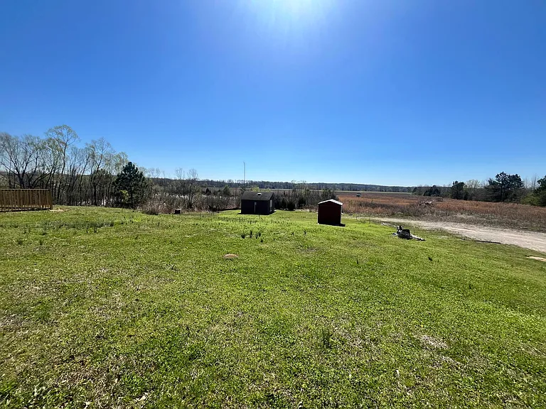 view from back yard is large field. property ends at the mower shed