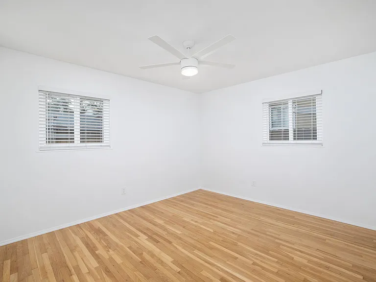 Bedroom #2 provides an even larger footprint, continuing the home's inviting aesthetic with natural light and a contemporary ceiling fan.