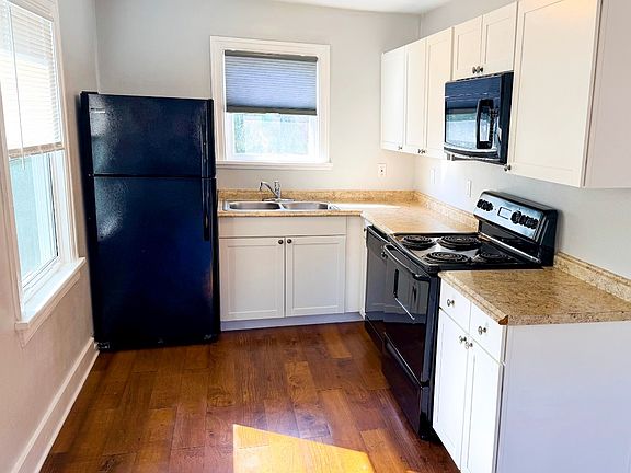 kitchen featuring modern cabinetry, dishwasher, microwave, and generous counter space.