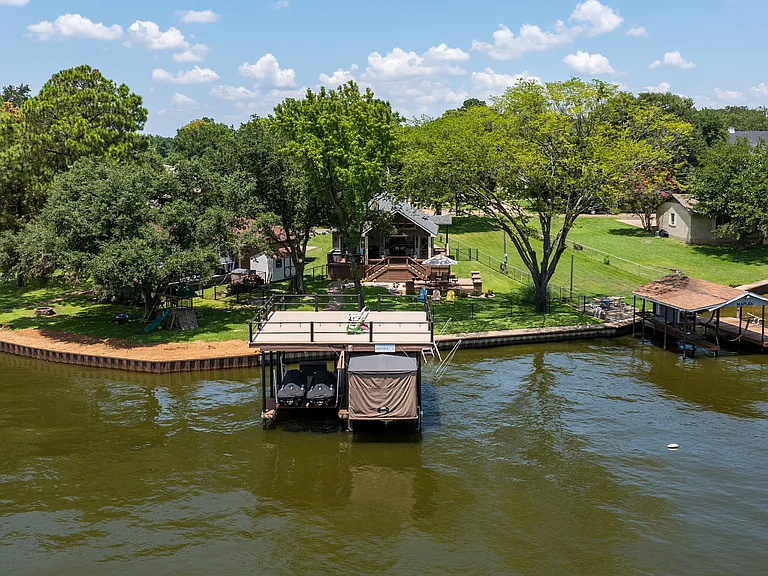 Backyard with covered patio and plenty of seating. With Access to lake and boat dock.