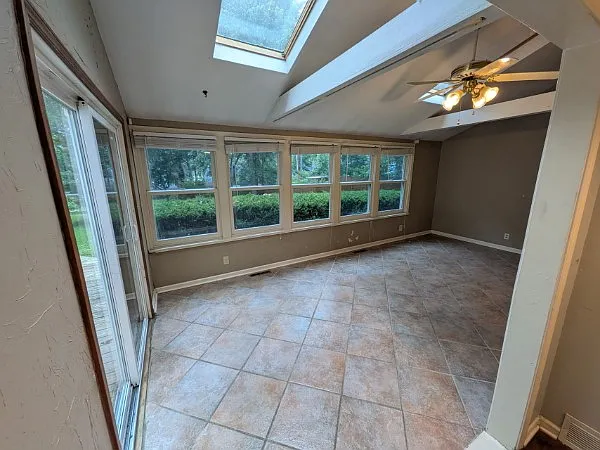 Sunroom Windows looks out on spacious fenced back yard.