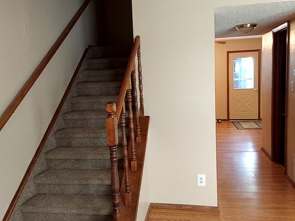 LIVING ROOM LOOKING INTO KITCHEN AREA, STAIRS GOING UP TO BEDROOMS