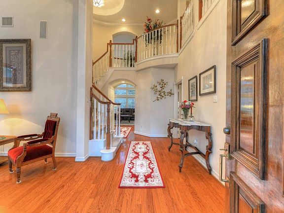 Gorgeous foyer offers soaring high ceilings, rich hardwood flooring, & beautiful winding staircase!