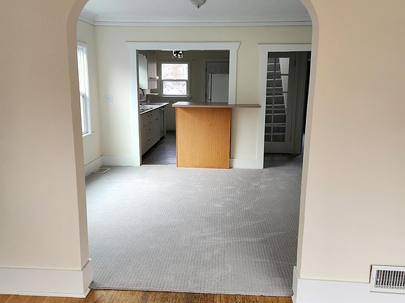View from living room, through separate dining area. Small bar at kitchen entry.