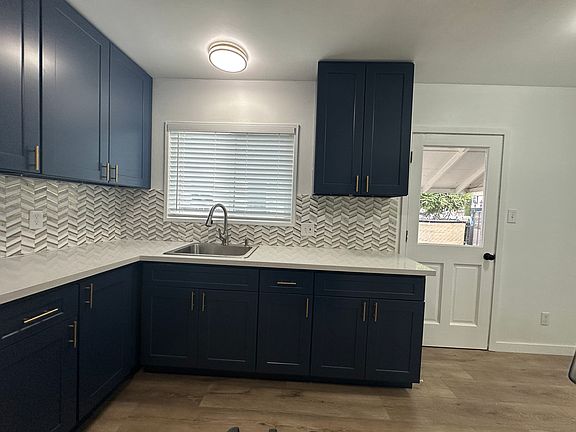 Gorgeous navy blue cabinets contrast beautifully with the white quartz counters and white/gold tile backsplash. All just installed and waiting for you.