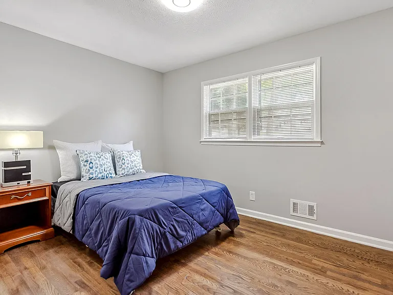Room 3 with full size bed, nightstand and lamp
