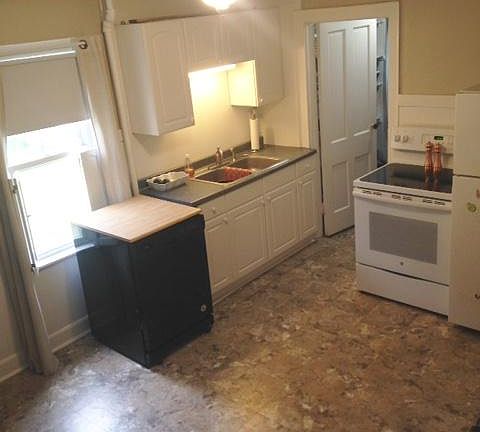 Kitchen and door leading to pantry next to stove.