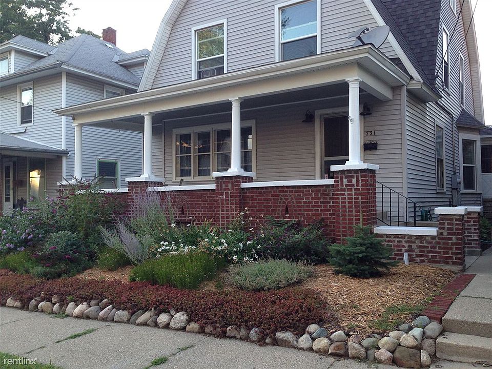 luxurious covered front porch includes dining table and chai