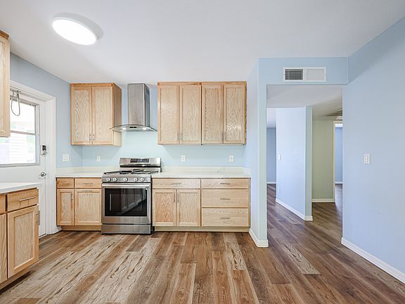 Another view of the kitchen showing entrance to living room and hallway to bedrooms.