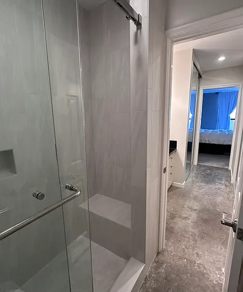 Newly remodeled custom master bath with sliding frameless glass doors and shower seat