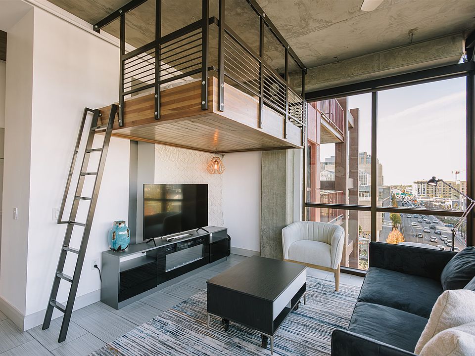 Open concept living space. Floor to ceiling windows. Living room and loft bed. TV and electric fireplace.