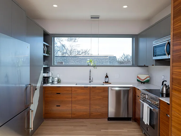 Compact kitchen fully stocked with all essentials and sleek stainless steel appliances_everything you need in a cozy space.