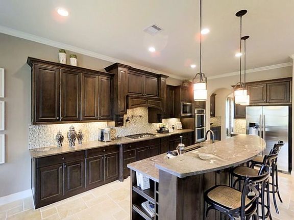 The stylish kitchen features a long center island with bar seating, high-end appliances and an open