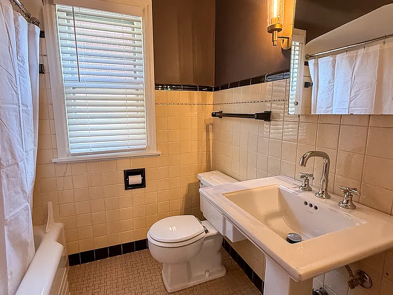 Classic vintage bathroom with Kohler pedestal sink and fixture.