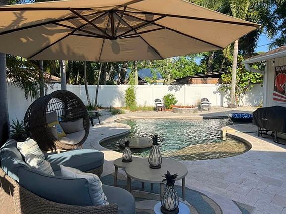 Showing Private backyard with Sunshelf, Table in pool and firepit beyond