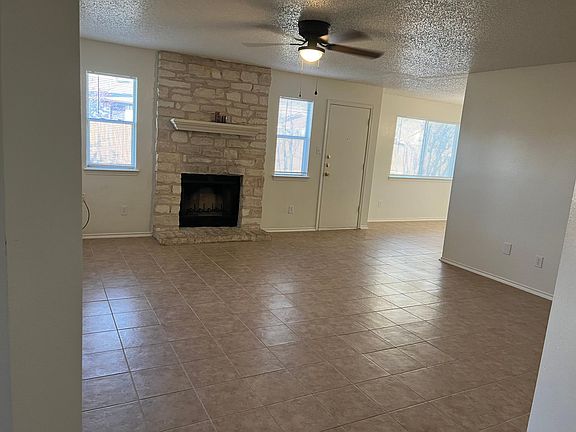 Large tiled Living room with brick fireplace.