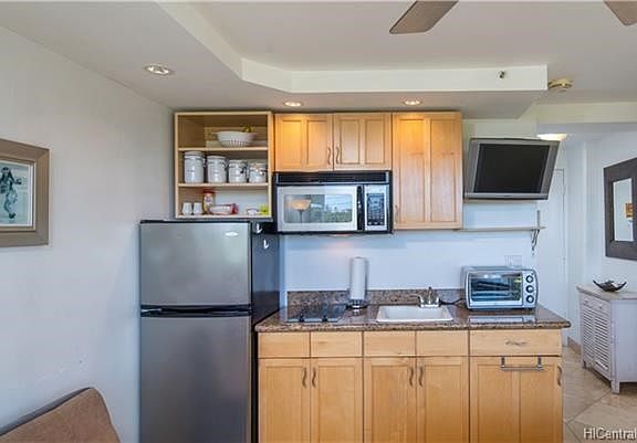 Convenient galley kitchen includes full sized refrigerator, stove/cooktop and microwave oven.