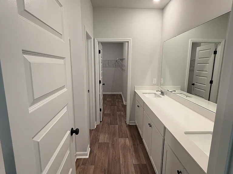 Primary bathroom with dual sinks, shower, toilet room and huge walk-in closet