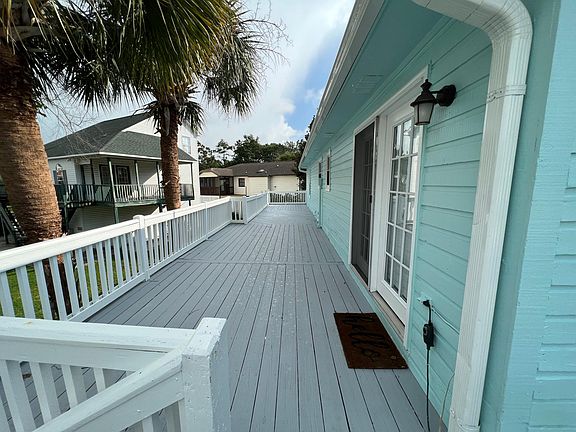 Huge deck great for entertaining. Twin palms beside it give the home a tropical feel.