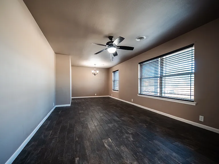 Bright family room with ceiling fan and large windows for natural light