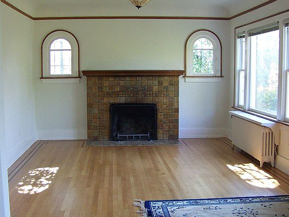 Living room with oak floors, oak trim, cove ceilings, and arched openings