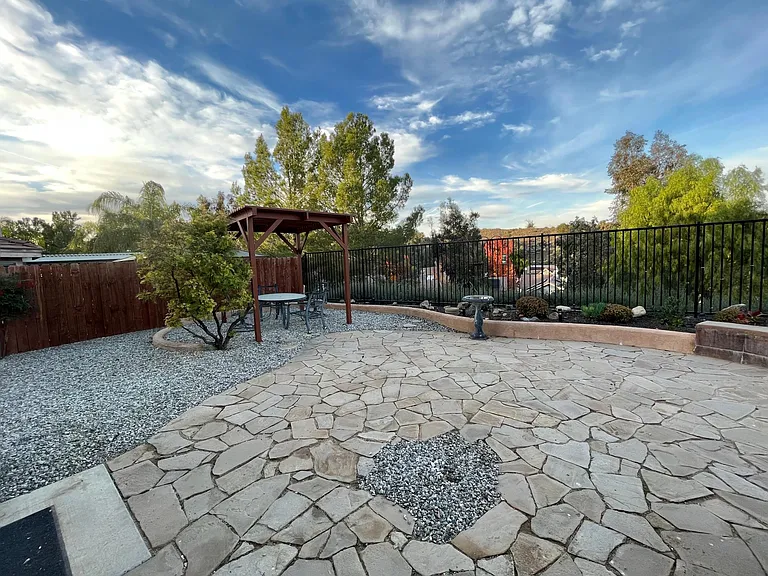 Large, fully landscaped rear yard with pergola, gas BBQ, and stunning views.