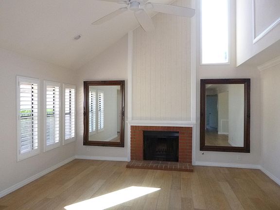 Living Room with vaulted ceiling, ceiling fan, recessed lighting, shutters, fireplace, and clerestory window.