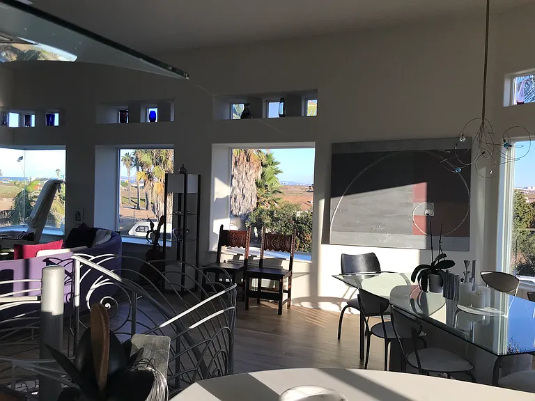 The dining area, living room, and kitchen are all in one large space, with views to the dunes and ocean.