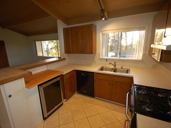 KITCHEN WITH VIEWS OF OCEAN AND FOREST.