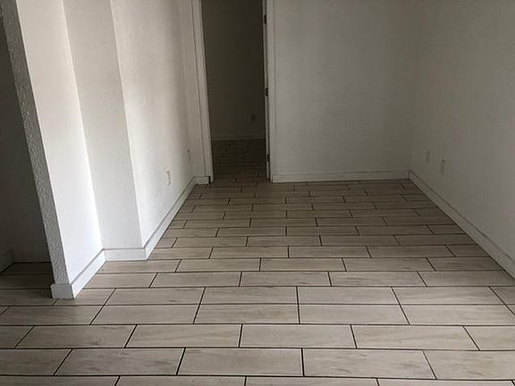 View (from laundry niche) of living area and door to bedroom.