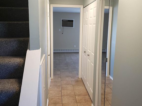Entry hallway with coat and utility closets on the right, half bath on the left.