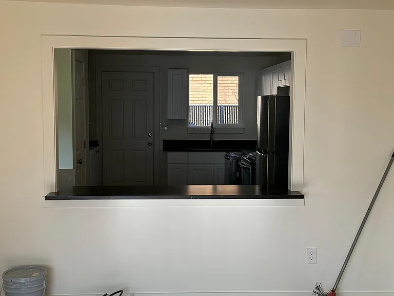 Living room and kitchen are connected with passthrough and small countertop.