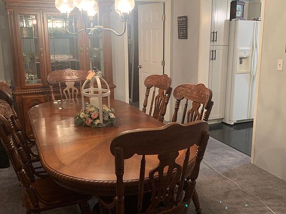 Large dining room comfortably seats up to 8 people with two leaves in the table, ambient lit glass hutch for additional storage and display space