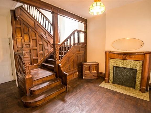 Bright entry way with fresh paint, refinished hardwood flooring, and original woodwork.