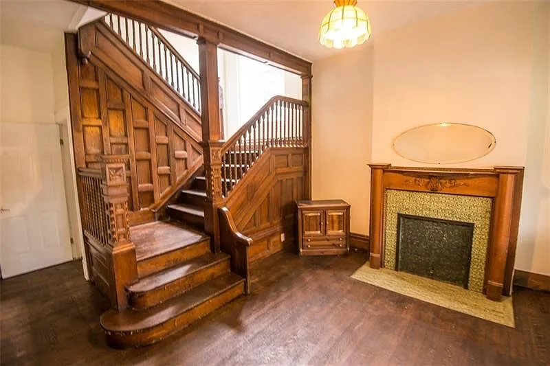 Bright entry way with fresh paint, refinished hardwood flooring, and original woodwork.