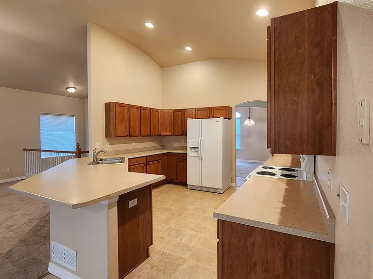 View of kitchen, bar area and doorway at the other end is across from the dining room