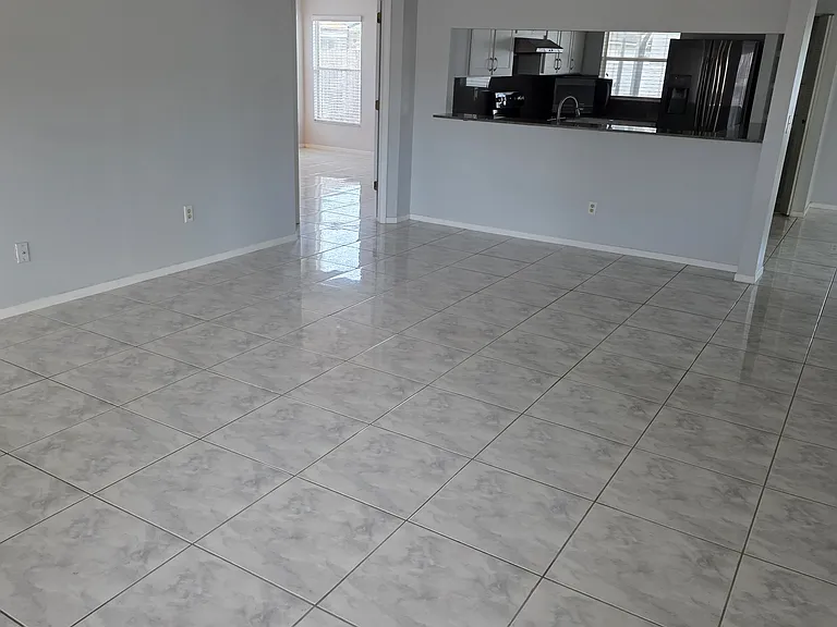 back to living room which shows master bedroom entrance (left) kitchen (middle) and right side which also leads to dining room area