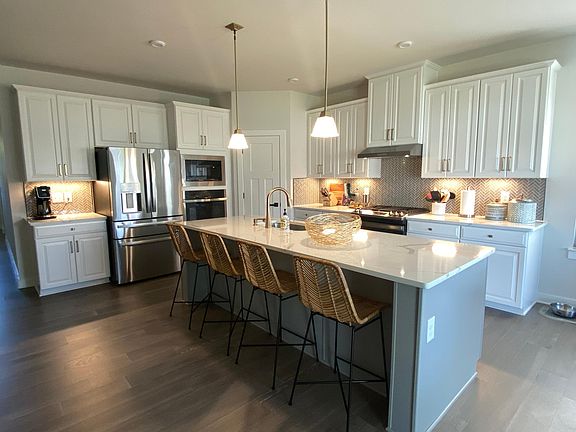 Amazing kitchen with gold faucet, gold handle and accents, gas range and wall oven with microwave.
