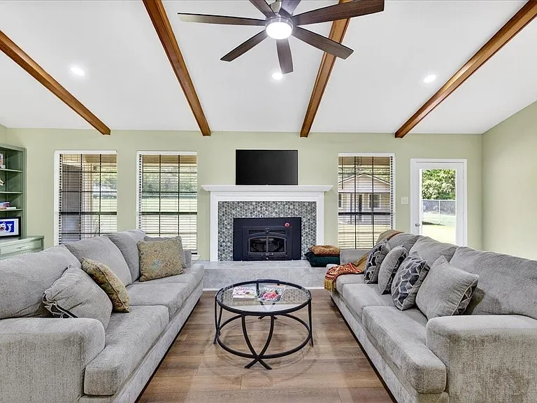 Open spacious living room is filled with light. The entertainment and storage wall to the left will hold mementos for all to see.