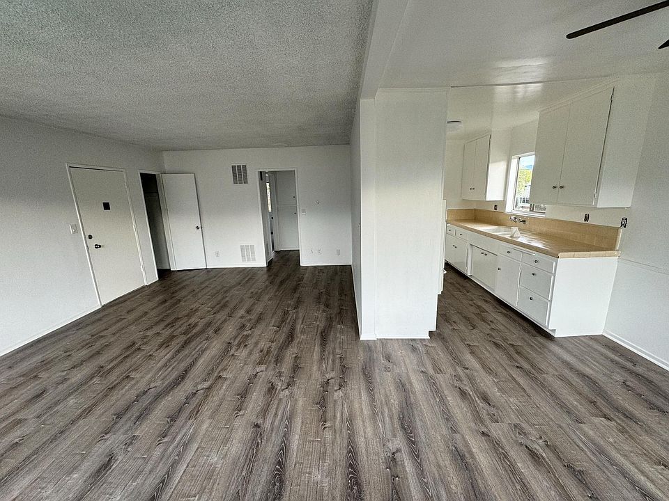 Newly painted living room and kitchen with newly installed wood floors.